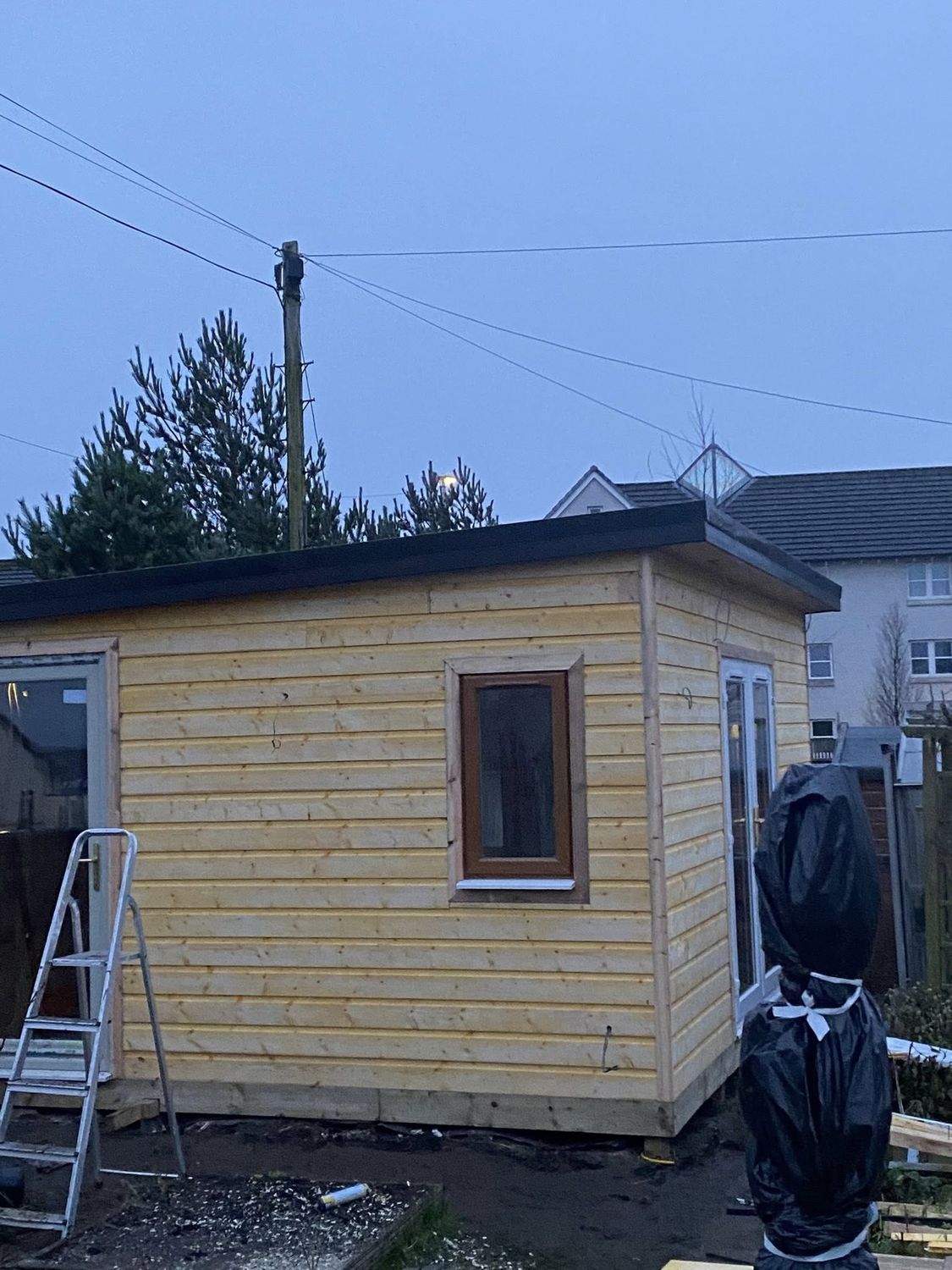 Timber-clad garden room at dusk